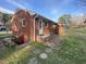 Rear view of a single-story brick home showing the backyard and basement entrance at 103 W Thorndale Dr, Oxford, NC 27565