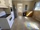 Cozy kitchen featuring white appliances, a tile floor, and a wooden cabinet next to stainless fridge at 103 W Thorndale Dr, Oxford, NC 27565