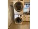 Laundry area with stacked washer and dryer unit, and a window with patterned curtains at 103 W Thorndale Dr, Oxford, NC 27565
