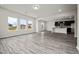 Bright, open-concept living room with wood-look floors and views into the kitchen with dark cabinets at 111 E Victory View Ter, Smithfield, NC 27577