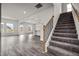 Bright, open-concept living room with wood-look floors, staircase, and views into the kitchen at 111 E Victory View Ter, Smithfield, NC 27577