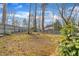 Private backyard with mature trees, mossy ground, and a classic wooden fence at 113 Bonner Ct, Cary, NC 27511