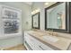 Bathroom featuring double vanity with stone countertop, brass fixtures, and framed mirrors at 113 Bonner Ct, Cary, NC 27511