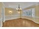 Formal dining room featuring hardwood floors, chandelier, and natural light from a bay window at 113 Bonner Ct, Cary, NC 27511