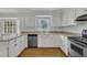 Bright kitchen featuring white cabinets, stainless steel appliances, and granite countertops at 113 Bonner Ct, Cary, NC 27511