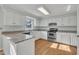 Well-lit kitchen with white cabinets, stainless steel appliances, and granite countertops at 113 Bonner Ct, Cary, NC 27511