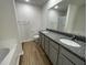 Modern bathroom with double sink vanity, granite countertops, and wood-look flooring at 12 Flatland Dr, Princeton, NC 27569
