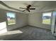 Large bedroom with tray ceiling, ceiling fan, neutral walls, and two bright windows at 12 Flatland Dr, Princeton, NC 27569