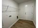 A laundry room with laminate wood flooring, shelving, and washer/dryer hookups at 12 Flatland Dr, Princeton, NC 27569