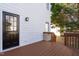 Inviting back porch with stained wood deck and black door to the home's interior at 1204 Matthews Glen Dr, Knightdale, NC 27545