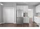 Bright kitchen with stainless steel refrigerator, white cabinets, and dark wood flooring at 1204 Matthews Glen Dr, Knightdale, NC 27545