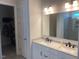 Bright bathroom featuring dual sinks, white cabinets, and a large mirror at 1216 Blue Mist Ct, Apex, NC 27502