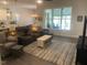 Cozy living room featuring hardwood floors, large windows, and comfortable seating at 1216 Blue Mist Ct, Apex, NC 27502