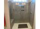 Modern shower with gray tiled walls, a bench, and glass enclosure at 1216 Blue Mist Ct, Apex, NC 27502