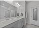 Bright bathroom featuring a double vanity with gray cabinets and a large mirror at 123 Liam St, Clayton, NC 27520