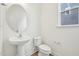 Powder room features pedestal sink, modern toilet, window, and neutral paint at 124 Willow Cameron Way, Angier, NC 27501