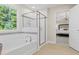 Bathroom with a soaking tub, glass shower, and views through a bright, sunny window at 124 Willow Cameron Way, Angier, NC 27501