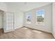 Bright bedroom with hardwood floors, two windows, neutral paint, and a glass paneled door at 124 Willow Cameron Way, Angier, NC 27501