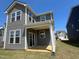 A view of the home's gray siding, white trim, and covered back patio at 124 Willow Cameron Way, Angier, NC 27501