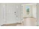 Bright foyer with hardwood floors, white walls, and a view into another room through french doors at 124 Willow Cameron Way, Angier, NC 27501