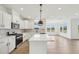 Bright kitchen features white cabinets, stainless steel appliances, and center island, opening to breakfast area at 124 Willow Cameron Way, Angier, NC 27501