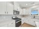 Modern kitchen with white cabinets, stainless steel appliances, tile backsplash, and light countertops at 124 Willow Cameron Way, Angier, NC 27501