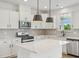 Beautiful kitchen with white cabinets, a tile backsplash, stainless steel appliances, and a large island at 124 Willow Cameron Way, Angier, NC 27501