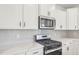 A close up of a kitchen with tile backsplash, stainless steel appliances, and white cabinets at 124 Willow Cameron Way, Angier, NC 27501