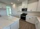 Modern kitchen with island, stainless steel appliances, quartz countertops, and sleek, white cabinetry at 124 Willow Cameron Way, Angier, NC 27501