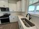 Well-appointed kitchen features stainless steel appliances, quartz countertops, and ample cabinet space at 124 Willow Cameron Way, Angier, NC 27501