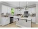 Modern white kitchen featuring an island, stainless steel appliances, and pendant lighting at 124 Willow Cameron Way, Angier, NC 27501