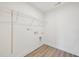 Compact laundry room featuring wire shelving for storage and new hardwood floors at 124 Willow Cameron Way, Angier, NC 27501
