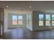 Bright living space with large windows, open concept design, hardwood floors, and modern chandelier lighting at 124 Willow Cameron Way, Angier, NC 27501