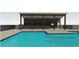 Inviting pool with modern covered patio, ceiling fans, and sleek metal safety fence offers a refreshing outdoor retreat at 124 Willow Cameron Way, Angier, NC 27501