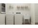 Laundry room with white washer, dryer, utility sink, and wire shelving at 1248 Hazelnut Ridge Ln, Knightdale, NC 27545