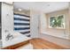 Bright bathroom featuring double sinks, a soaking tub, and a separate shower with blue and white shower curtain at 12808 Old Stage Rd, Willow Springs, NC 27592