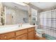 Vintage bathroom with floral wallpaper, a shower, and a white vanity with storage at 12808 Old Stage Rd, Willow Springs, NC 27592
