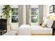 Comfortable bedroom features two windows with curtains, a wooden bed frame, and sleek black furniture at 1308 Hazelnut Ridge Ln, Knightdale, NC 27545