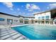 Resort-style pool featuring deck chairs, umbrellas, and modern architecture of the apartment complex on a sunny day at 1308 Hazelnut Ridge Ln, Knightdale, NC 27545
