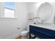 Elegant powder room features a navy vanity, round mirror, and marble countertop at 149 Bonica Creek Dr, Garner, NC 27529