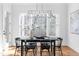 Dining room with a black table, black chairs, and modern chandelier with a view of the trees outside the window at 149 Bonica Creek Dr, Garner, NC 27529
