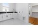 Bright laundry room with white cabinetry, a black countertop, and tile flooring at 149 Bonica Creek Dr, Garner, NC 27529