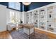 Bright office with modern chandelier, white built-in shelving, dark blue accent paint, and comfortable seating at 149 Bonica Creek Dr, Garner, NC 27529