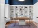 Office space featuring custom built-in shelving, desk, stylish decor, and dark blue accent wall at 149 Bonica Creek Dr, Garner, NC 27529