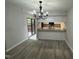 Open concept dining area with modern light fixture and view of the kitchen and back deck at 159 Finley Forest Dr, Chapel Hill, NC 27517