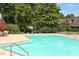 Community pool is surrounded by lush trees and a safety fence at 159 Finley Forest Dr, Chapel Hill, NC 27517