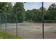 A fenced-in community tennis court with trees in background at 159 Finley Forest Dr, Chapel Hill, NC 27517