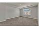 Unfurnished bedroom featuring tray ceiling, carpeted floor, and window view of neighborhood at 1723 Starlit Sky Ln, Cary, NC 27519
