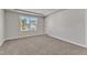 Unfurnished bedroom featuring carpeted floor, window with neighborhood view, and walk-in closet at 1723 Starlit Sky Ln, Cary, NC 27519