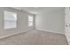 Bright bedroom with neutral carpet, two windows, and a closet door at 1723 Starlit Sky Ln, Cary, NC 27519